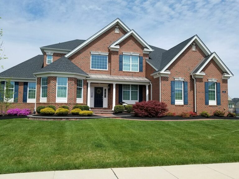 Brick home with a manicured, freshly mowed lawn and mulched flower beds